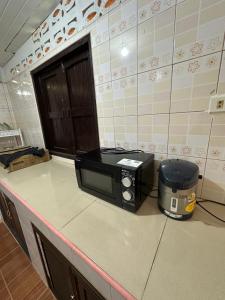 a microwave sitting on a counter in a kitchen at Ploy Chumpoo Kantiang in Ko Lanta