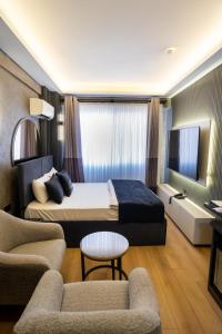 a hotel room with a bed and two chairs at Inn City Park Hotel in Burunabat