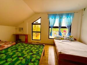 a bedroom with two beds and a window at TUBURAN Poolside in Nagsulang +23 photos
