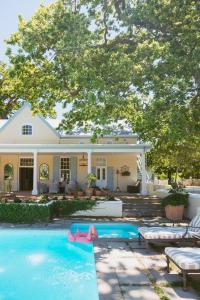a swimming pool in front of a house at Auberge Clermont in Franschhoek