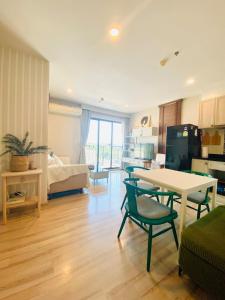 a kitchen and living room with a table and chairs at The Base Height Condo with Rooftop infinity pool in Ban Sam Kong