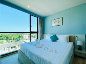 a bedroom with a large bed with a large window at The Base Height Condo with Rooftop infinity pool in Ban Sam Kong +38 photos