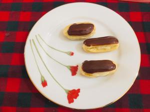 two chocolate covered donuts on a white plate at Mimi's Cottage in Udawalawe +47 photos