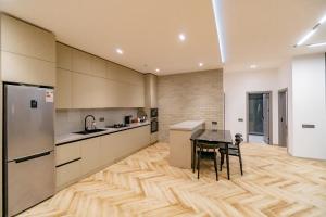 a kitchen with a wooden floor and a table at White villas in Qusar