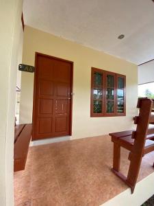 a living room with a wooden door and a bench at Thip Thip Ressort Ao Nang in Ban Khlong Haeng