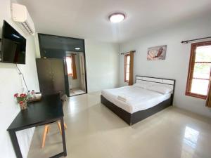 a bedroom with a bed and a desk in it at Thip Thip Ressort Ao Nang in Ban Khlong Haeng