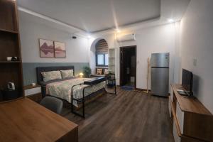 a bedroom with a bed and a desk and a refrigerator at START HOUSE AIRPORT 5-MIN WALK Warm Stay, Easy Flight in Ho Chi Minh City