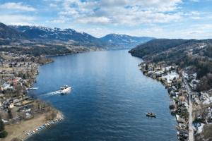 a boat on a lake with mountains in the background at Apartment Seeboden in Seeboden