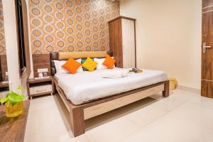 a bedroom with a bed with orange and yellow pillows at goSTOPS Amritsar, Golden Temple in Amritsar