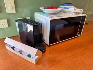 a microwave and a box on a wooden floor at McLaren Flat Studio in McLaren Flat