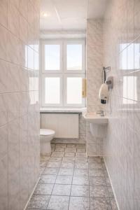 a bathroom with a toilet and a sink and a window at Hotel Mazowiecki WOW in Warsaw +88 photos