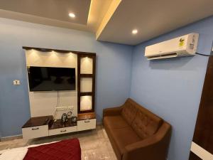 a living room with a couch and a television at erode kongu mess in Chennai +6 photos