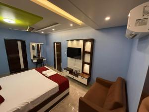 a bedroom with a bed and a couch and a television at erode kongu mess in Chennai