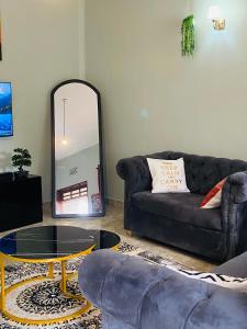 a living room with a couch and a mirror at Tulivu Nyumba in Arusha