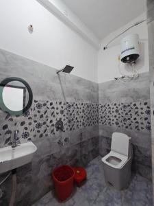 a bathroom with a sink and a toilet and a mirror at Parth Guest House in Ayodhya