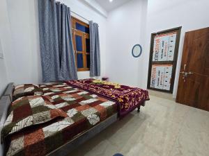 a bedroom with a bed with a quilt on it at Parth Guest House in Ayodhya