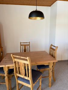 a wooden dining room table with two chairs and a lamp at Ferienhaus Tobie in Ahlefeld