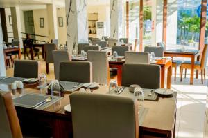 a dining room with tables and chairs and tablesktop at Lavendish Beach Resort in Unawatuna