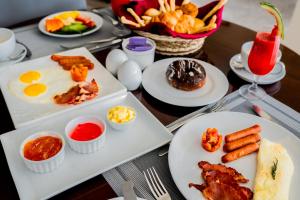 a table with plates of breakfast food on it at Lavendish Beach Resort in Unawatuna