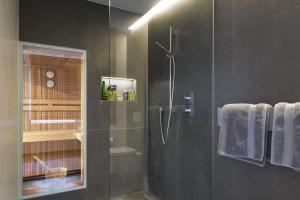 a bathroom with a shower with a glass door at MountainRelaxKtzh in Kitzbühel +7 photos
