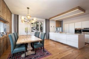 a kitchen and dining room with a wooden table and chairs at MountainRelaxKtzh in Kitzbühel