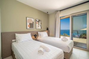 two beds in a room with a view of the ocean at Villa Katoikia Dio by Villa Plus in Simotáta +18 photos