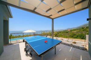 a ping pong table with a view of the ocean at Villa Katoikia Dio by Villa Plus in Simotáta
