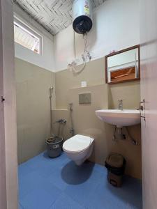 a bathroom with a toilet and a sink at Providence Guest House in Churāchāndpur