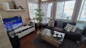 a living room with a couch and a flat screen tv at Genuine Beach House and Sauna in Pello
