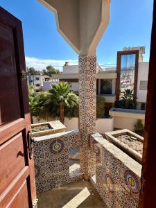 an open door to a balcony with a tiled pillar at Villa ben lahbib in Khenifra