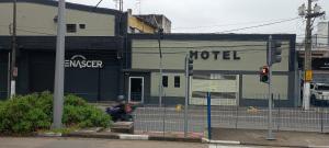 a man is sitting in front of a hotel at Hotel metrosul Ltda in São Paulo