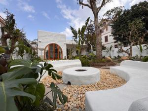 a garden with white concrete benches in front of a house at AnB Garden in Ða Gia
