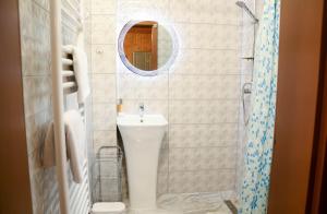 a bathroom with a sink and a toilet and a mirror at Vila Adela in Lacu Rosu +28 photos