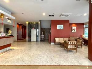 a lobby with a couch and a table in a building at Hatyai Golden Crown Hotel in Hat Yai