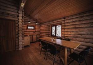 a dining room in a log cabin with a table and chairs at Gnishik Eco Lodge in Gnishik