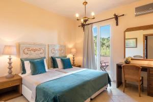 a bedroom with a bed and a desk and a mirror at Villa Kalliopi by Villa Plus in Agnítsini