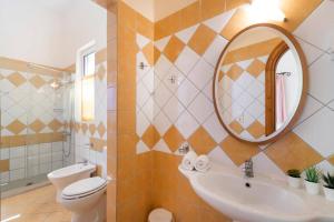 a bathroom with a sink and a toilet and a mirror at Villa Kalliopi by Villa Plus in Agnítsini +34 photos