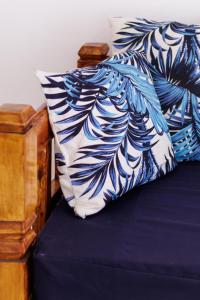 a bed with a blue and white pillow on it at Azara Watamu in Watamu