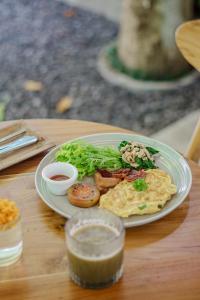 a plate of breakfast food on a wooden table at Lembu Putih House in Tegalalang