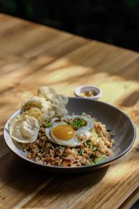 a plate of food with an egg and bread on a table at Lembu Putih House in Tegalalang