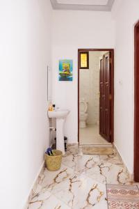 a bathroom with a sink and a toilet at Azara Watamu in Watamu +15 photos