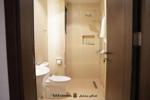 a bathroom with a toilet and a sink at SAS Central in Salalah +26 photos