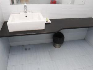 a bathroom with a white sink and a black counter at Heritage Tezpur in Tezpur +19 photos