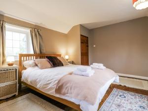 a bedroom with a bed with towels on it at White Gates in Norwich