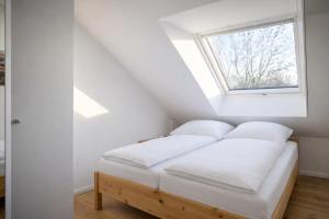 a bed in a room with a window at Gulfhof Wangermeer 1 Lotta in Hohenkirchen