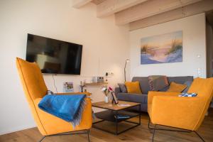 a living room with a couch and a table at Gulfhof Wangermeer 1 Lotta in Hohenkirchen