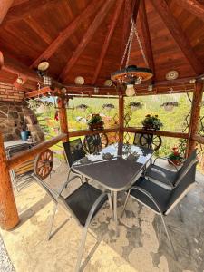 a dining room with a table and chairs on a porch at Vila Adela in Lacu Rosu