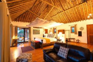 a bedroom with a bed and a couch in a room at Tawi Lodge in Amboseli +33 photos