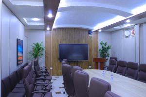 a conference room with a table and chairs and a tv at Maximum Hotel in Navoi