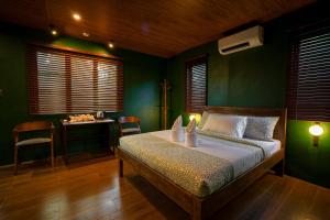 a bedroom with a bed with green walls and a desk at Aran Villas in Santa Maria